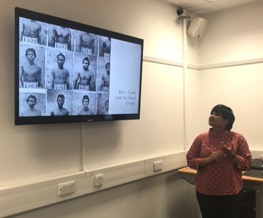 Image of presenter in seminar room delivering slide presentation